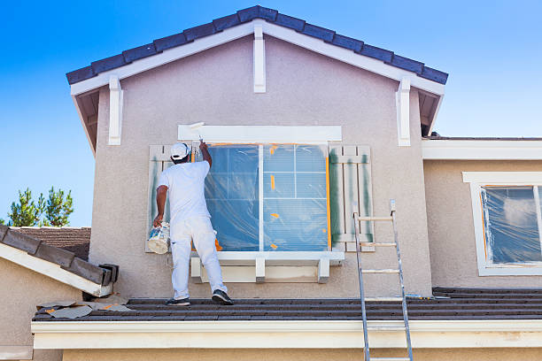 busy house painter painting the trim and shutters of a home.